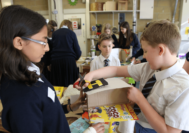 Year 8 Leighton Park pupil helps pupil from St Mary’s School, Henley with STEM activity involving cardboard boxes